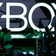 Microsoft VP of gaming Phil Spencer standing in front of an Xbox logo.